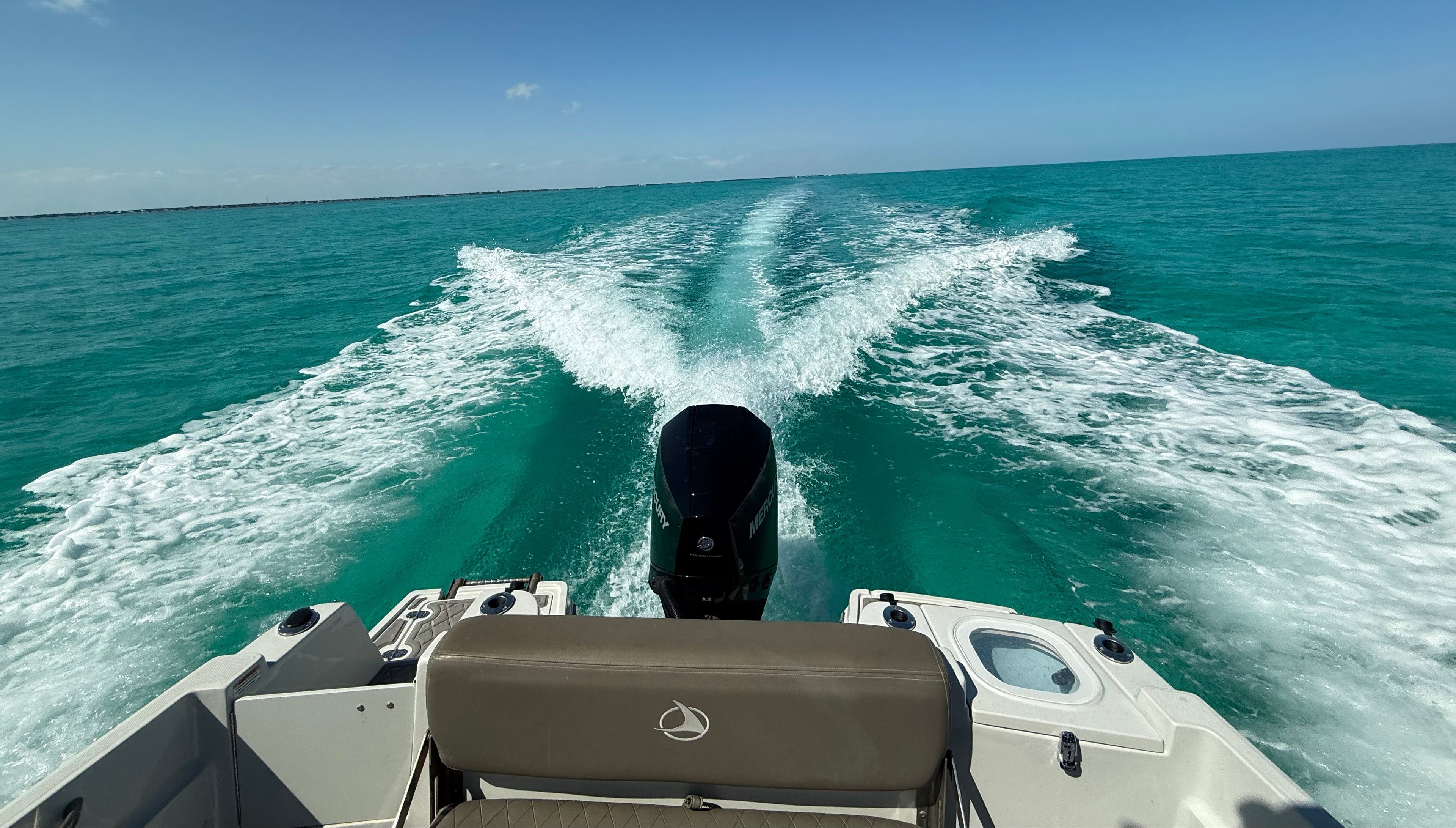 Boat moving through water with a clear blue sky